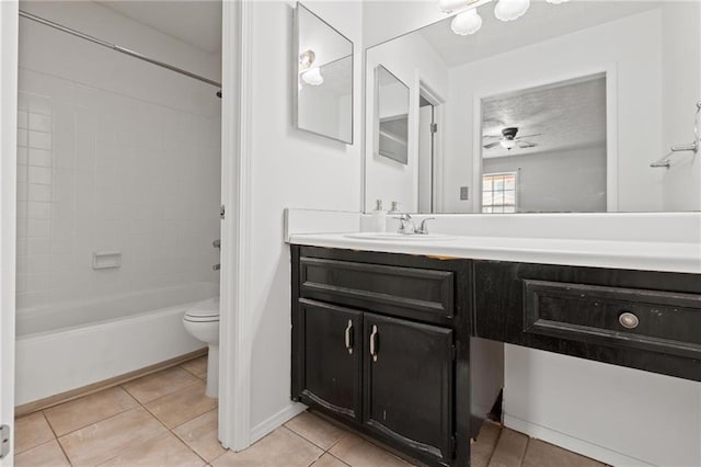 full bathroom featuring tile patterned flooring, vanity, tiled shower / bath combo, ceiling fan, and toilet