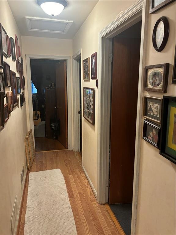 corridor with radiator heating unit and light hardwood / wood-style floors