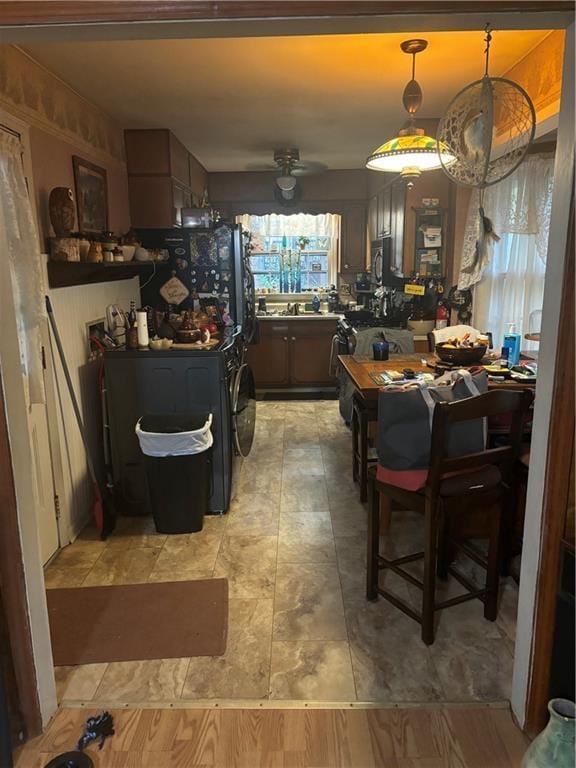 kitchen featuring black refrigerator, decorative light fixtures, ceiling fan, and sink