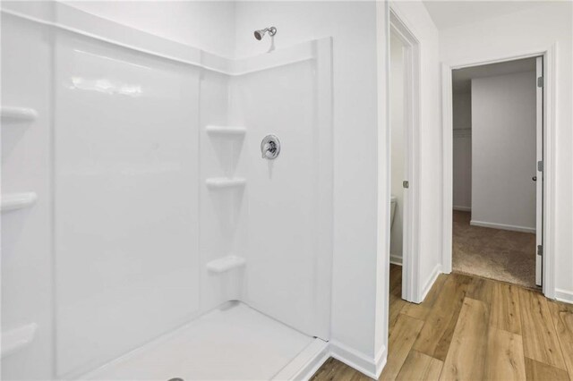 bathroom featuring walk in shower and wood-type flooring