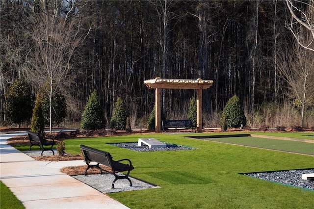 view of community featuring a pergola and a lawn