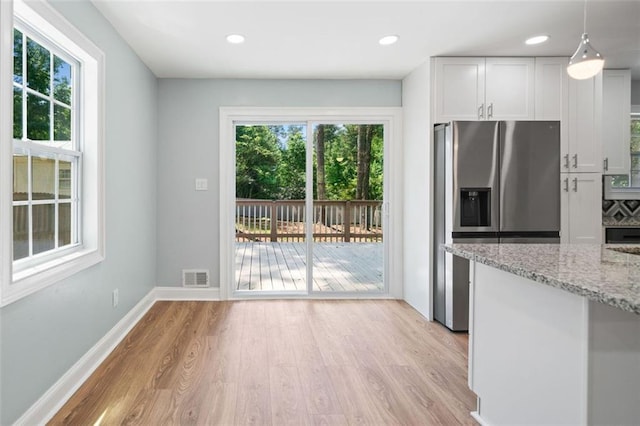 3050 Woodland Dr NW, Kennesaw, GA 30152 - kitchen featuring stainless steel refrigerator with ice dispenser, light wood-style floors, light stone countertops, white cabinetry, and baseboards