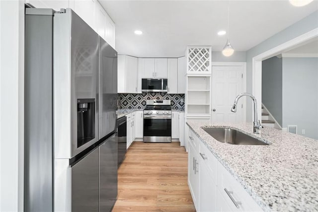 3050 Woodland Dr NW, Kennesaw, GA 30152 - kitchen featuring stainless steel appliances, a sink, white cabinetry, tasteful backsplash, and light stone countertops
