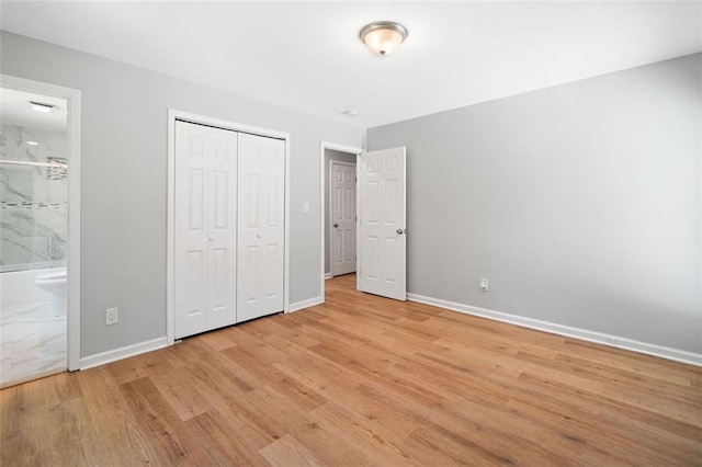 3050 Woodland Dr NW, Kennesaw, GA 30152 - unfurnished bedroom with light wood-type flooring, baseboards, a closet, and connected bathroom