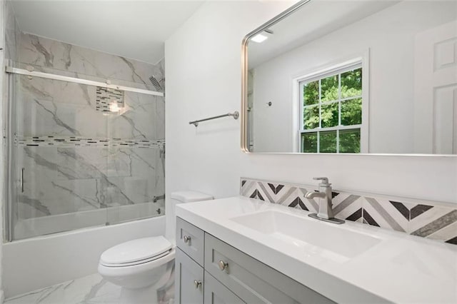 3050 Woodland Dr NW, Kennesaw, GA 30152 - full bath featuring marble look tiles, toilet, vanity, and combined bath / shower with glass door