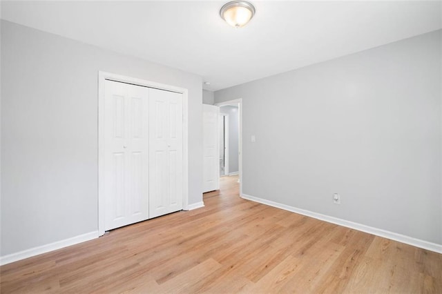 3050 Woodland Dr NW, Kennesaw, GA 30152 - unfurnished bedroom with baseboards, light wood-style flooring, and a closet