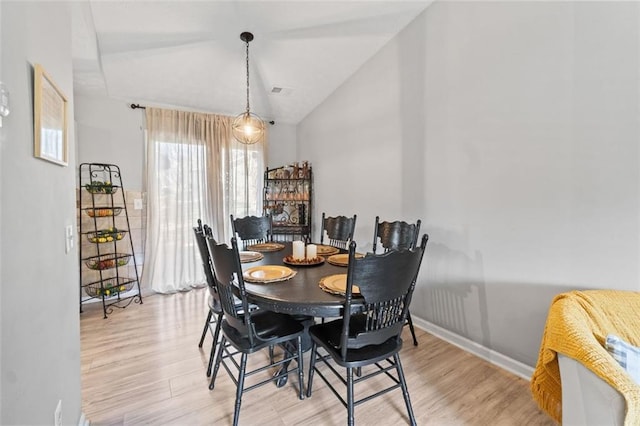 dining area with vaulted ceiling, light wood-style floors, and baseboards