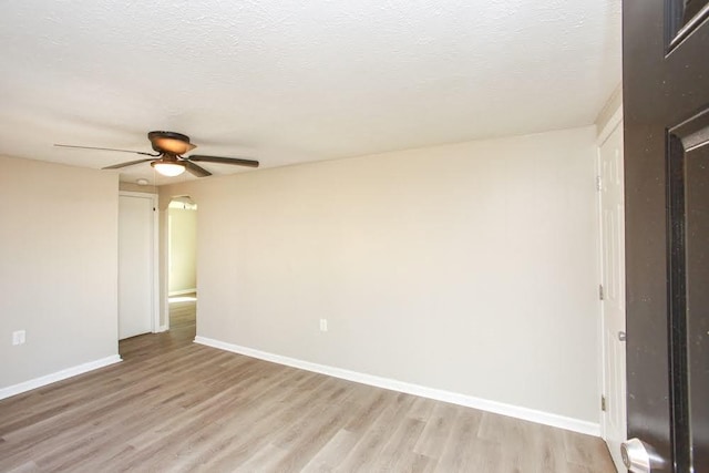 272 Old Sudie Rd, Hiram, GA 30141 - unfurnished room with light wood-type flooring, baseboards, a ceiling fan, a textured ceiling, and arched walkways