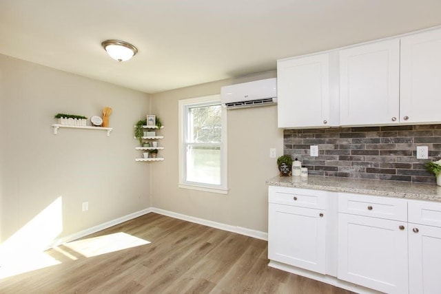272 Old Sudie Rd, Hiram, GA 30141 - kitchen featuring a wall mounted air conditioner, light wood-style flooring, tasteful backsplash, and white cabinetry
