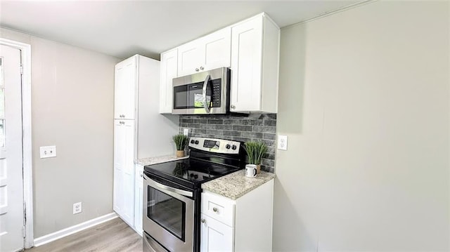 272 Old Sudie Rd, Hiram, GA 30141 - kitchen with appliances with stainless steel finishes, white cabinetry, light wood-style flooring, light stone countertops, and tasteful backsplash