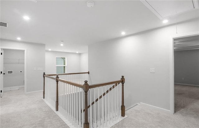 hall with attic access, recessed lighting, light colored carpet, and an upstairs landing