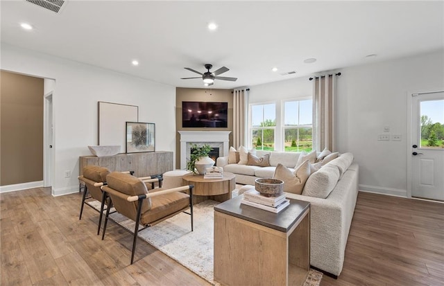 living area featuring a healthy amount of sunlight, ceiling fan, and visible vents