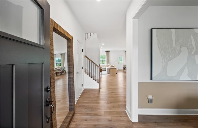 interior space with baseboards, stairs, and wood finished floors
