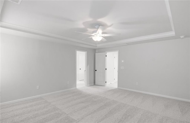 unfurnished room featuring carpet floors, a ceiling fan, a tray ceiling, and baseboards