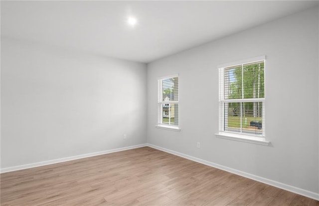 spare room with light wood-type flooring and baseboards