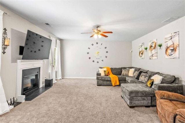 living area featuring visible vents, a fireplace with flush hearth, ceiling fan, and carpet flooring