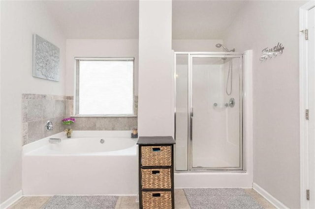 full bath featuring baseboards, a garden tub, and a shower stall