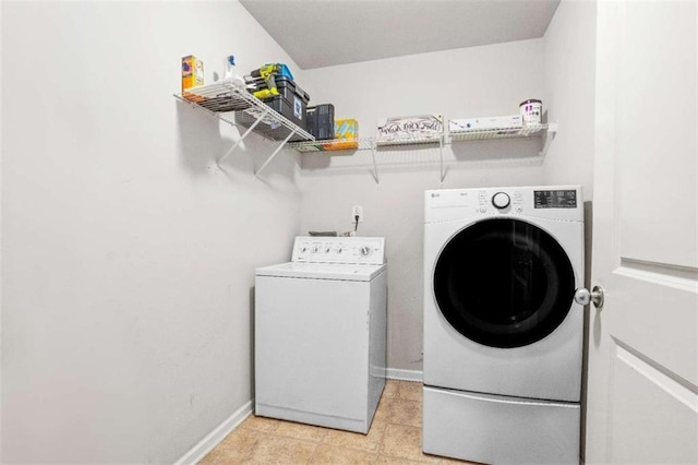 laundry area featuring laundry area, washing machine and dryer, and baseboards