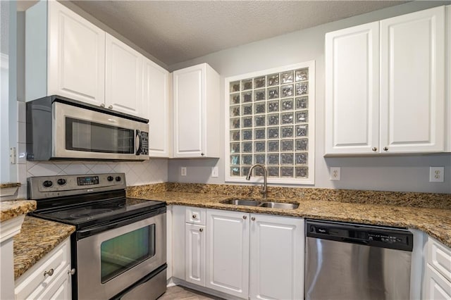 10 NE Perimeter Summit Blvd Unit 3107, Atlanta, GA 30319 - kitchen with stainless steel appliances, white cabinetry, decorative backsplash, light stone countertops, and a textured ceiling