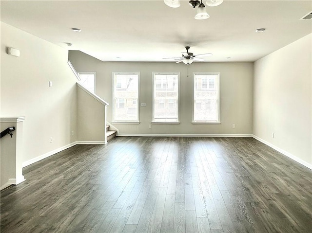 3658 Hidden Valley Cir, Lawrenceville, GA 30044 - unfurnished living room featuring dark wood-style floors, stairs, ceiling fan, baseboards, and visible vents