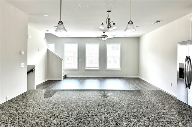 3658 Hidden Valley Cir, Lawrenceville, GA 30044 - unfurnished living room featuring ceiling fan with notable chandelier, baseboards, visible vents, and dark wood-style flooring