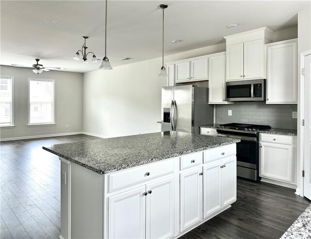 3658 Hidden Valley Cir, Lawrenceville, GA 30044 - kitchen featuring ceiling fan with notable chandelier, appliances with stainless steel finishes, a center island, and dark wood-style floors