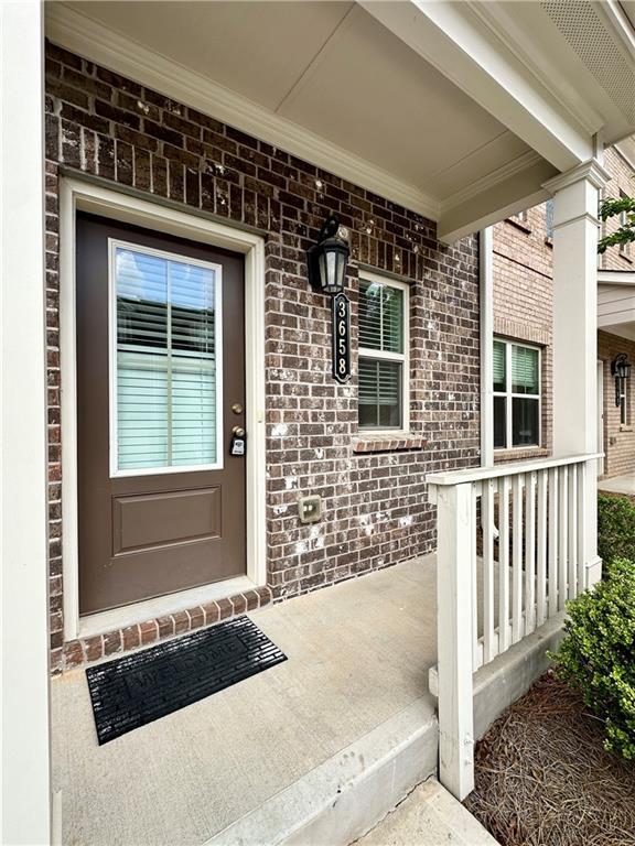 3658 Hidden Valley Cir, Lawrenceville, GA 30044 - view of exterior entry with brick siding and a porch