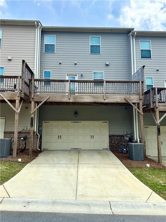 3658 Hidden Valley Cir, Lawrenceville, GA 30044 - back of property featuring concrete driveway, a deck, cooling unit, and a garage