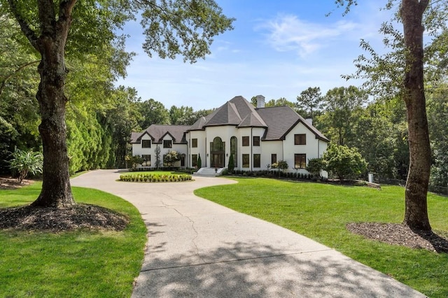 330 Longvue Ct, Johns Creek, GA 30097 - french country home with curved driveway, a chimney, a front yard, and stucco siding