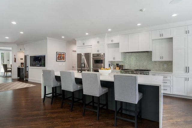330 Longvue Ct, Johns Creek, GA 30097 - kitchen featuring crown molding, stainless steel appliances, an island with sink, backsplash, and light countertops