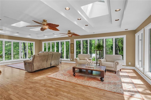 1819 Yorkshire Dr, Woodstock, GA 30189 - living area featuring light wood finished floors, a skylight, a raised ceiling, and a healthy amount of sunlight