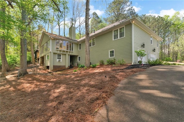 1819 Yorkshire Dr, Woodstock, GA 30189 - rear view of property with a chimney, driveway, and a garage