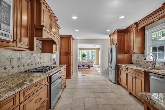 1819 Yorkshire Dr, Woodstock, GA 30189 - kitchen with stone countertops, recessed lighting, brown cabinetry, appliances with stainless steel finishes, and a sink