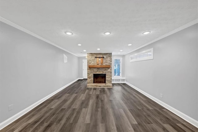 unfurnished living room with dark hardwood / wood-style flooring, ornamental molding, and a stone fireplace