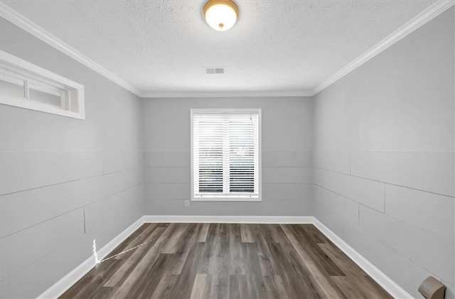 unfurnished room featuring dark hardwood / wood-style floors, ornamental molding, and a textured ceiling