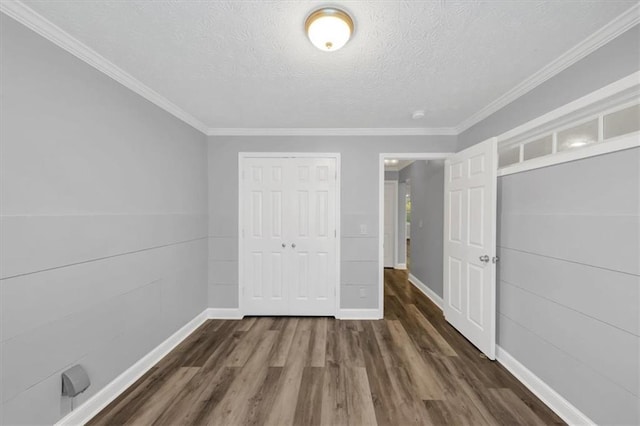 unfurnished bedroom featuring a closet, dark wood-type flooring, crown molding, and a textured ceiling