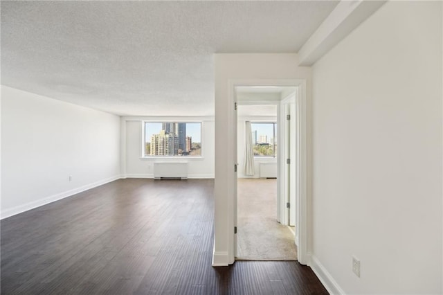 2479 Peachtree Rd NE Unit 1703, Atlanta, GA 30305 - unfurnished living room with dark wood-type flooring, plenty of natural light, a textured ceiling, and radiator