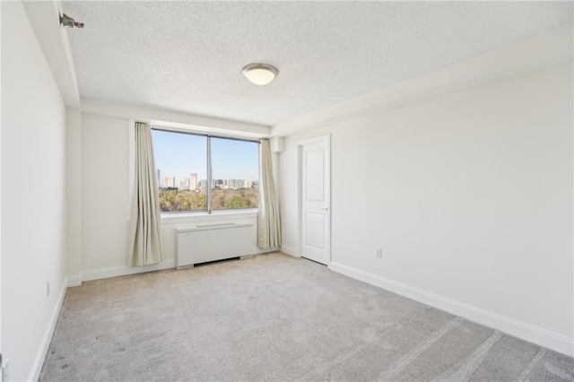 2479 Peachtree Rd NE Unit 1703, Atlanta, GA 30305 - unfurnished room with a textured ceiling, light carpet, and radiator