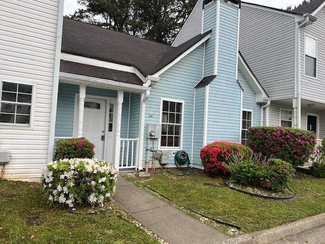 doorway to property featuring a porch and a yard