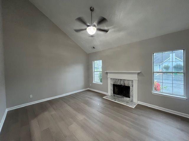 unfurnished living room featuring ceiling fan, baseboards, a fireplace, dark wood-type flooring, and high vaulted ceiling