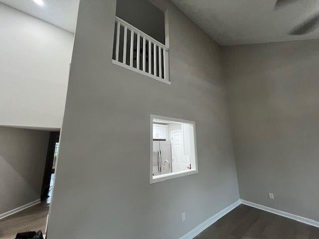 interior space with wood finished floors, freestanding refrigerator, and baseboards