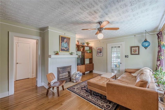 2669 Jefferson Ter, East Point, GA 30344 - living room featuring ornamental molding, wood finished floors, a fireplace with flush hearth, ceiling fan, and a textured ceiling