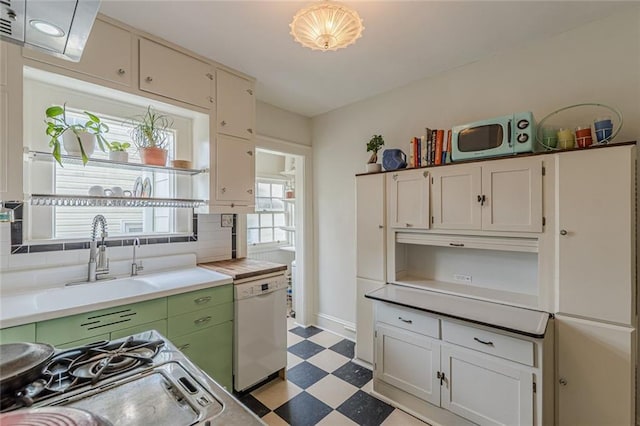 2669 Jefferson Ter, East Point, GA 30344 - kitchen with white dishwasher, light floors, light countertops, backsplash, and gas range