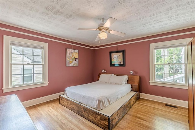 2669 Jefferson Ter, East Point, GA 30344 - bedroom with light wood-style flooring, baseboards, a textured ceiling, a ceiling fan, and crown molding