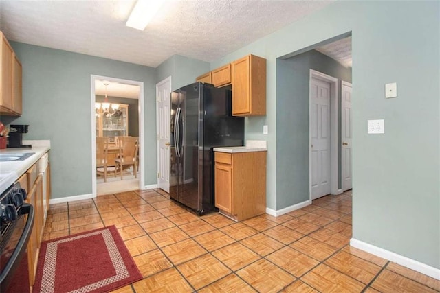 kitchen featuring light tile patterned floors, a textured ceiling, black range, stainless steel fridge with ice dispenser, and a notable chandelier