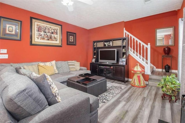 living room featuring wood-type flooring and ceiling fan