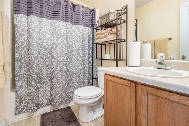 bathroom with tile patterned flooring, curtained shower, vanity, and toilet