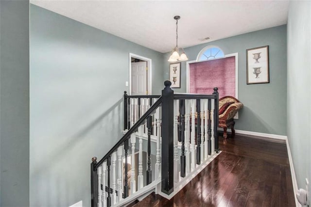 staircase with an inviting chandelier and hardwood / wood-style floors