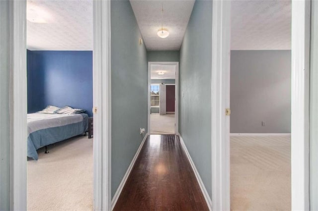 hallway featuring a textured ceiling and hardwood / wood-style floors