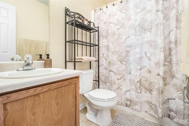 bathroom featuring a shower with curtain, vanity, tile patterned flooring, and toilet